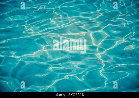 Azure clear water in a swimming pool with sun reflecting Stock Photo