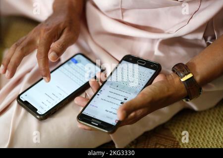Man using two smartphones. Internet, game, Instagram and Faced Book. Close-up on hands.  Vietnam. Stock Photo