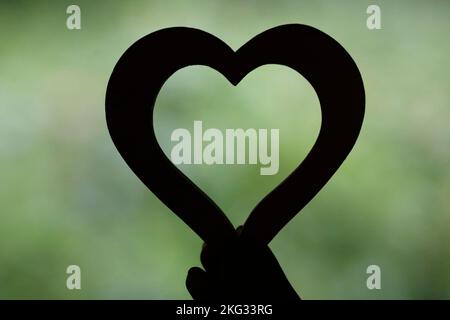 Woman holding a wooden heart. Close-up on hand. Love concept. Stock Photo