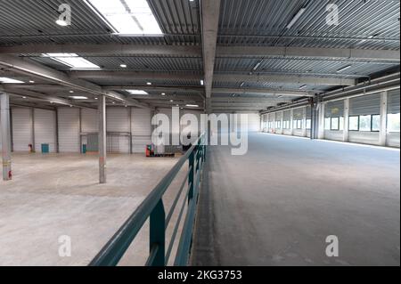 Shot of empty storehouse surrounded with shutter walls under steel roof Stock Photo
