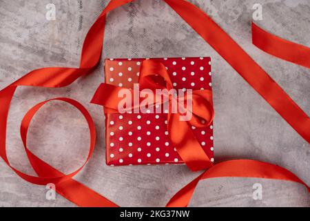 Gift and red ribbon on gray background Stock Photo