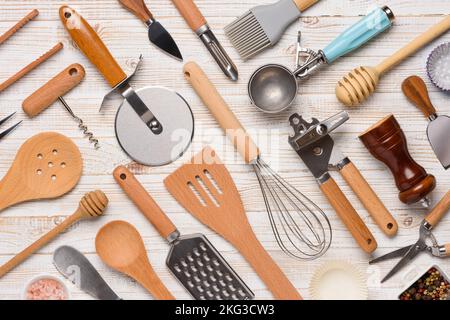 Set of kitchen utensils pattern on white wooden table background top view. Various cooking tools flat lay. Stock Photo