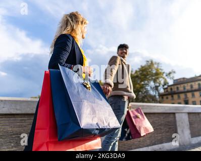selective focus on shopping bags of Young couple walking in the city with shopping bags, shopping time Stock Photo