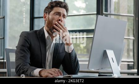 Portrait tired lazy napping yawn adult bearded man male manager worker bored at work project online in computer in office Caucasian mature ill Stock Photo