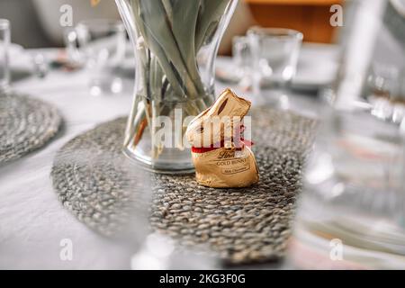18 April 2022 Krakow, Poland: Happy Easter holiday. Golden chocolate Lindt Easter Rabbit on white table background. Easter banner. Stock Photo