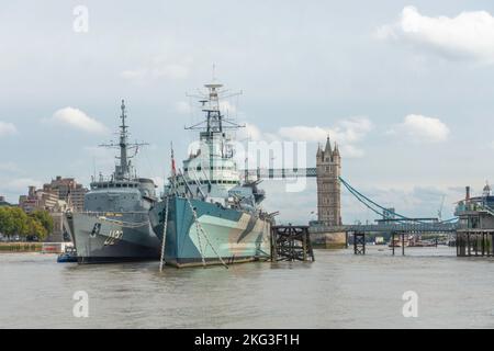 HMS Belfast anchored on the River Thames in London with Tower Bridge in the background and training ship Brasil U27 from Brazil alongside. Stock Photo
