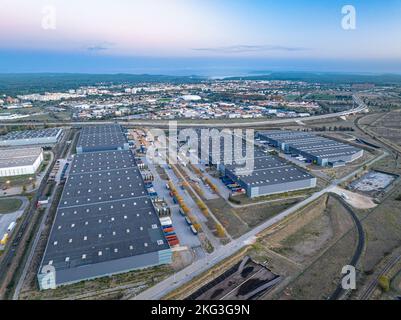 Drone shot of rooftops of factories in the middle featuring tranquillity and main road on both sides in the evenings Stock Photo