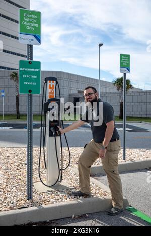 New Electric Vehicle Charging Stations. Spencer Davis, a NASA Traffic Management specialist in the Spaceport Integration Directorate at NASA’s Kennedy Space Center in Florida, stands near a newly installed electric vehicle (EV) charging station near the Central Campus Headquarters Building at Kennedy on Sept. 14, 2022. Part of a partnership between Kennedy and Florida Power & Light (FPL) to bring 23 EV charging stations to the spaceport, the ChargePoint CT4000, Level 2 chargers are capable of charging electric vehicles at a rate of 15-30 miles of range per hour. This partnership was set up und Stock Photo