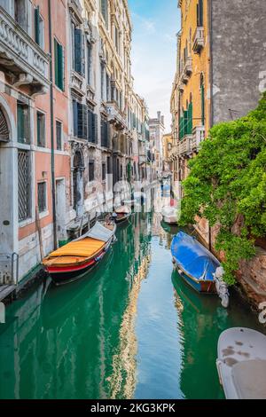 Moored boats on small canal in city of Venice, Italy. Stock Photo