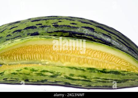 The Armenian cucumber, Cucumis melo var. flexuosus, a type of long, slender fruit which tastes like cucumber and looks somewhat like a cucumber inside Stock Photo