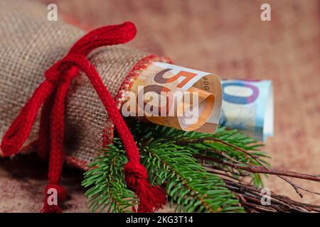 Jute sack with fir greenery and banknotes Stock Photo