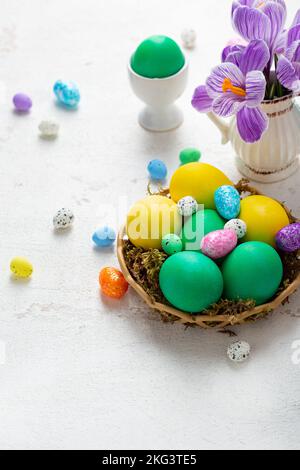 Spring flowers in pitcher Easter background color eggs Stock Photo