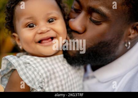 Loving parent kissing his beautiful baby on the cheek Stock Photo