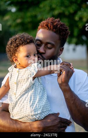 Affectionate dad kissing his child on the cheek Stock Photo