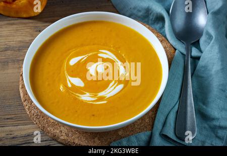 bowl of pumpkin soup on kitchen table Stock Photo