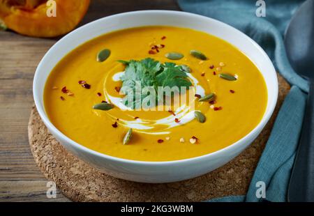 bowl of pumpkin soup on kitchen table Stock Photo
