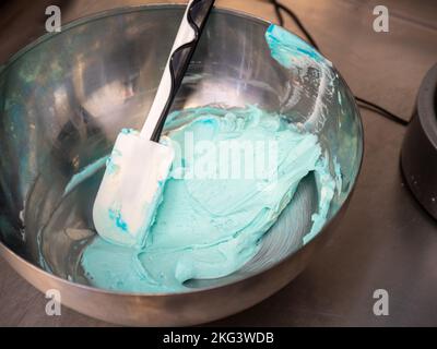 chef preparing pink and blue filling for piping bag for frosted icing cake decoration Stock Photo