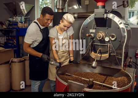 Pleased roast masters monitoring the coffee roasting process Stock Photo