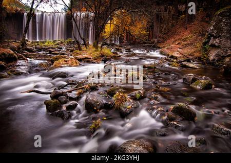 Waterfall and creek in a beautiful autumn day Stock Photo