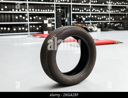Tire placed on gray floor against shelves in spacious workshop of modern store Stock Photo