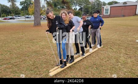 221028-N-LY580-1017 ALEXANDER CITY, Ala. (Oct. 28, 2022) Benjamin Russell High School Navy Junior Reserve Officers Training Corps Cadets, left-right, Courtney Burgess, Katherine Taylor, Austin Kenney, Lylaishia Brown, Andrew Ramirez and Jacob Corbin use shuttle boards to move from station to station during teamwork exercises. BRHS,Benjamin Russell,NETC,NJROTC,NSTC,teamwork, Stock Photo
