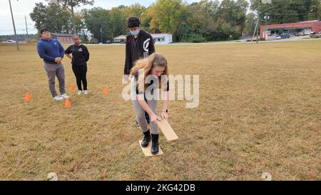 221028-N-LY580-1012 ALEXANDER CITY, Ala. (Oct. 28, 2022) Benjamin Russell High School Navy Junior Reserve Officers Training Corps Cadets Katherine Taylor and Jacob Corbin, foreground, use wooden boards to move from station to station during teamwork exercises. BRHS,Benjamin Russell,NETC,NJROTC,NSTC,teamwork, Stock Photo