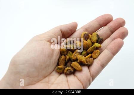 Pistachio's without shells. Pistachio in a woman's hands. Pistachio nuts is a healthy vegetarian protein and nutritious food. Chili seasoning nuts. Stock Photo