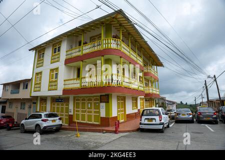 Filandia, Quindio, Colombia - June 5 2022: A Yellow and Orange Colonial Big House with Wooden Balcony on a Cloudy Day Stock Photo