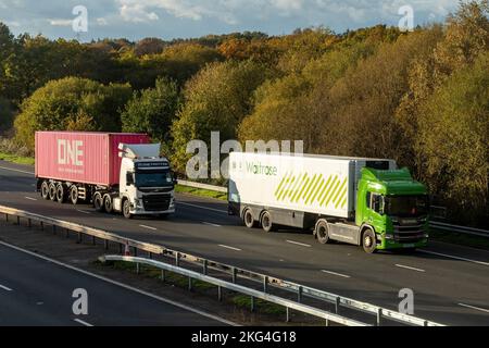 Two HGVs, Waitrose and One (Ocean Network Express) lorries travelling along the M3 motorway, England, UK Stock Photo