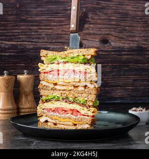 A close-up shot of a tall cut club sandwich on a plate Stock Photo