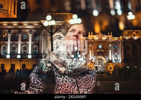 Happy young redhead hungarian urban woman in leopard pattern coat at winter at night, Buda Castle, Budapest, Hungary. Double exposure technique Stock Photo