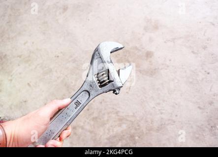 Adjustable spanner in a hand, industrial spanner isolated Stock Photo