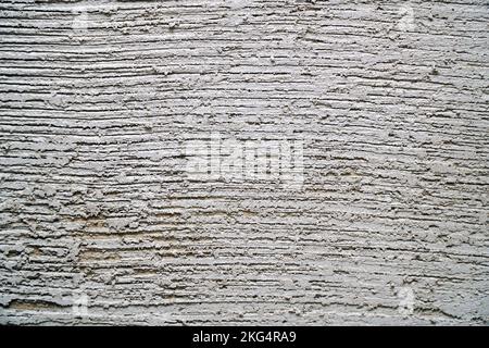 Gray decorative plaster on the wall with pressed horizontal stripes. Plaster background Stock Photo