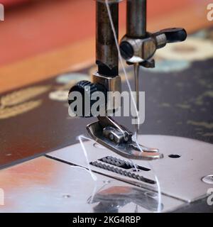 Sewing needle with thread on a sewing machine. Soft focus. Selective focus Stock Photo