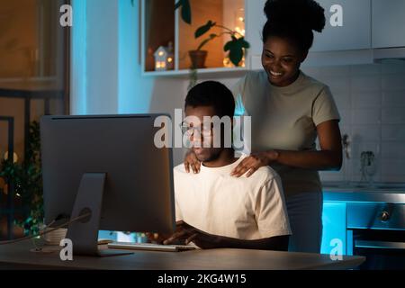 Loving wife support freelance web designer husband working on small business project from home late Stock Photo