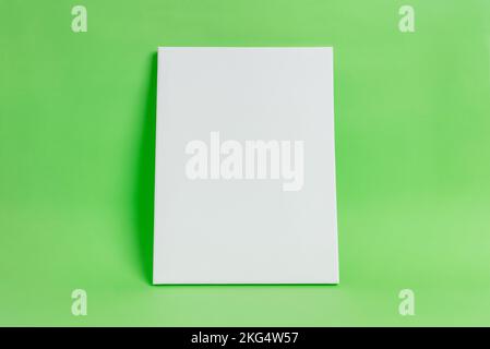 White art canvas on green surface. Clean, blank surface for mockup, art presentation. Art template Stock Photo