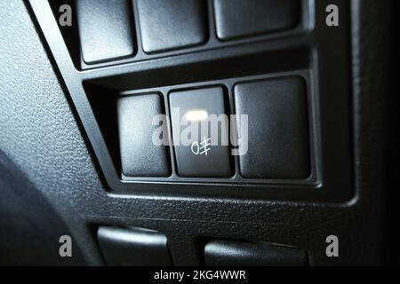 Automotive spotlight button switch on dashboard in the car, The indicator light is on. Stock Photo