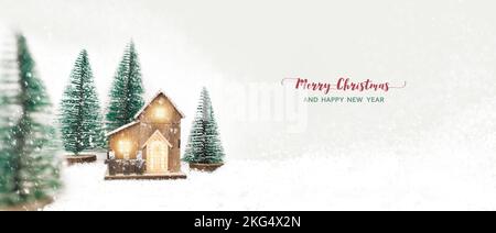 Merry Christmas and New Year festival concept, model wooden houses and pine trees between snowy mountains in winter season, panoramic banner and text Stock Photo