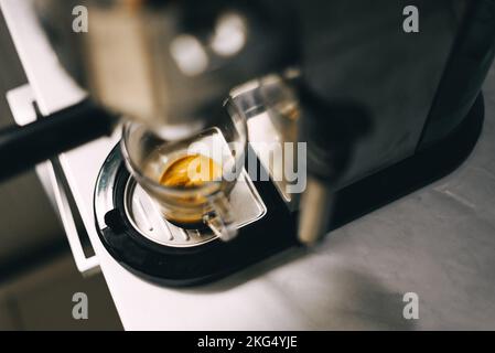 Coffee machine filling a cup with expresso. Transparent mug in automated coffeemaker machine. Beverage drink for breakfast Stock Photo