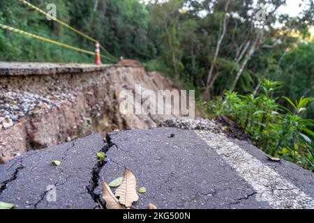 asphalt road damaged by a landslide in a mountain area Stock Photo