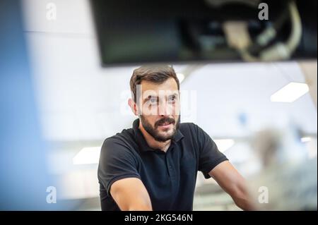 Professional worker printmaker technician operator works in printing press hall and printshop office with many different type of machine Stock Photo