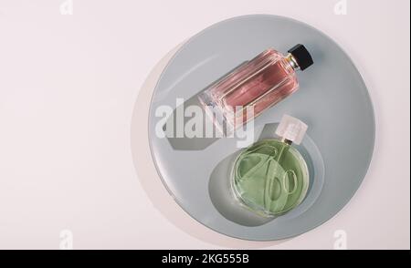 Two woman perfume bottles on a grey plate Stock Photo