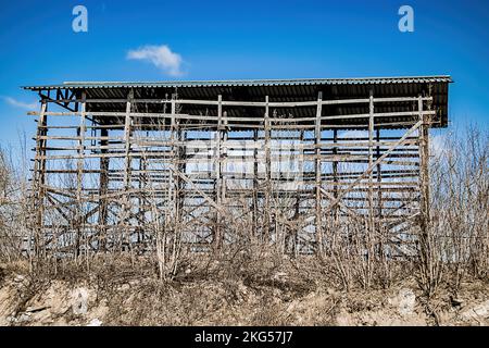 Old destroyed construction site. Rusty scaffolding and construction equipment. Industrial buildings in abandoned factory. Stock Photo