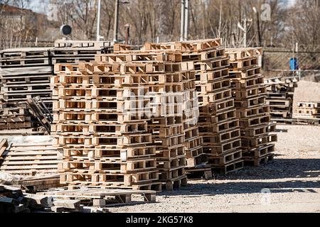 Stack of wooden pallets in warehouse. Industrial logistics and transportation. Pallets at construction site. Stock Photo