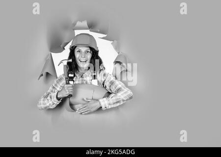 equipment for repairing. mechanic girl in protective hardhat. building and construction. professional manual worker. technician working using hammer Stock Photo