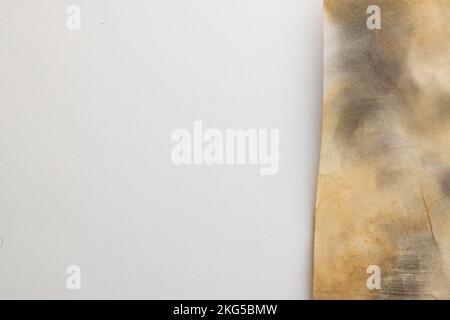 Burned and stained piece of paper with copy space on white background Stock Photo