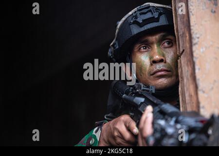 A soldier assigned to the Maneuver Team Company apart of the Indonesian Army Tentara National Indonesia Angkatan Darat (TNI-AD) 127th Batallion, pulls security out of a window during Joint Pacific Multinational Readiness Center Rotation (JPMRC) 23-01 at Schofield Barracks , Hawaii, Oct. 31, 2022. Troops from the Indonesian Army TNI-AD and 5th Security Forces Assistance Brigade will work hand in hand during the duration of JPMRC 23-01 to receive realistic training and bolster relations between the U.S. and other partner forces throughout the Indo-Pacific. Stock Photo