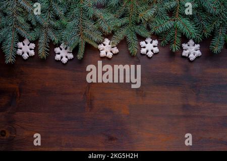 top view on natural rustic wood table surface. Fir tree branches border with copy space. Christmas decoration, frame concept background Stock Photo