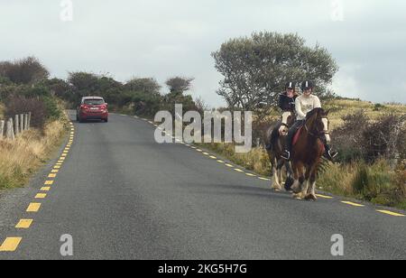 Dublin, Ireland. 2nd Oct, 2022. 20221002 - A pair of horseback riders trot down a paved road in northern County Donegal, Ireland. (Credit Image: © Chuck Myers/ZUMA Press Wire) Stock Photo