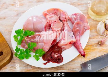 Chopped rabbit with garlic and spices on white plate with knife Stock Photo